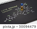 Close-up blue cap sample vial on black notebook 30094479