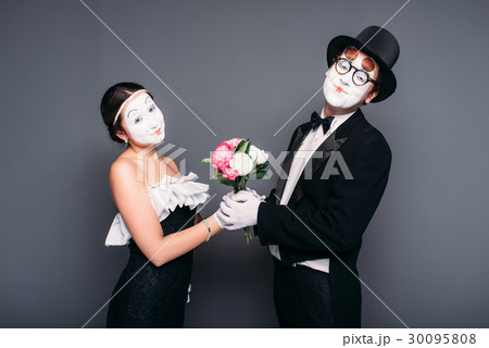 Pantomime actors performing with flower bouquet 30095808