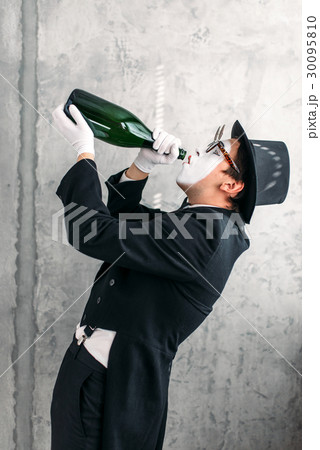 Mime actor drinking from a big bottle Mime actor drinking from a big bottle 30095810
