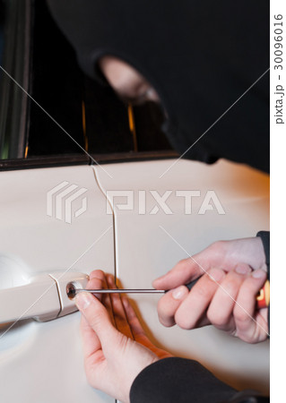 Male thief hands open car door with screwdriver Male thief hands open car door with screwdriver 30096016