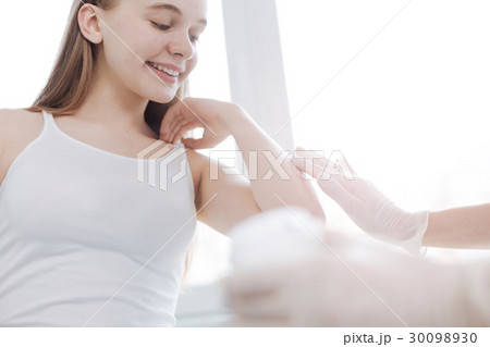 Delighted girl enjoying visit to the dermatologist 30098930