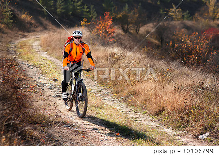 Cyclist in the orange jacket riding a bike on Cyclist in the orange jacket riding a bike on 30106799