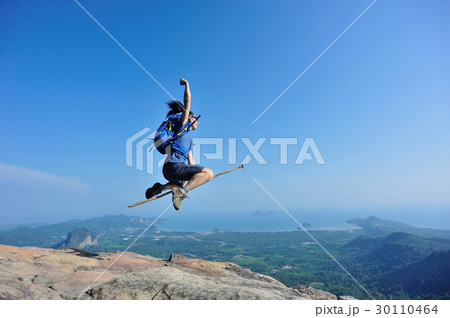 successful woman jumping on rocky mountain peak successful woman jumping on rocky mountain peak 30110464