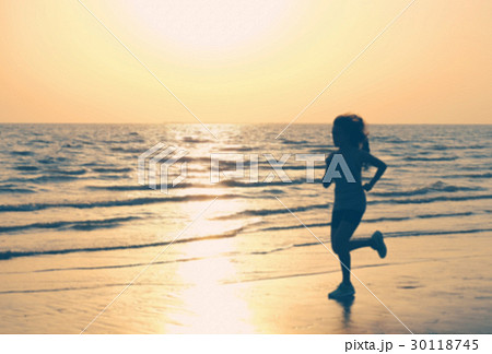 Woman Running on the Beach and Sunset. Photo Blur. 30118745