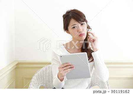 部屋でタブレットを使う女性 部屋でタブレットを使う女性 30119162