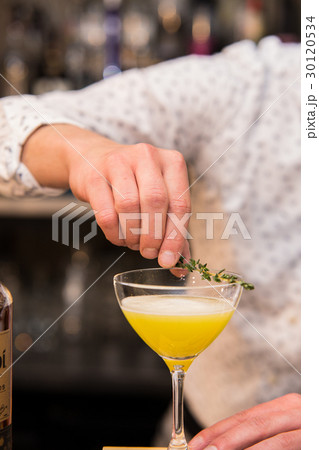 Barman putting lemon peel to prepare coctail Barman putting lemon peel to prepare coctail 30120534