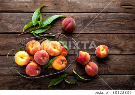 Fresh peaches fruits with leaves in basket Fresh peaches fruits with leaves in basket 30122839
