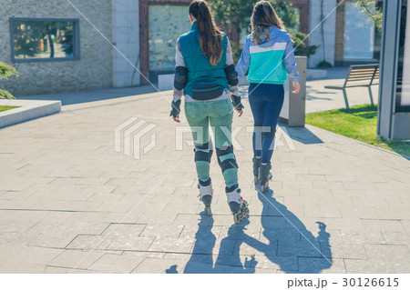 Two girls rollers go one after another 30126615