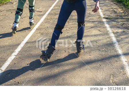 Two girls ride on rollers on a very bad road Two girls ride on rollers on a very bad road 30126618