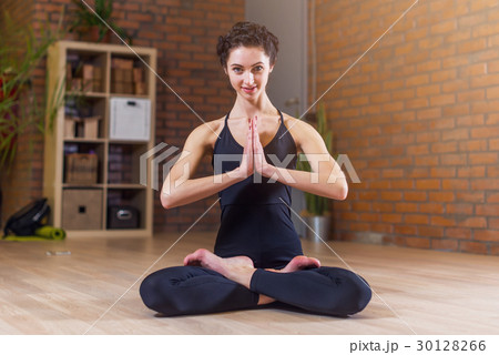 Woman doing yoga meditating in full lotus pose 30128266