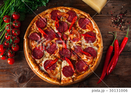 Tasty pepperoni pizza served on dark wood Tasty pepperoni pizza served on dark wood 30131006