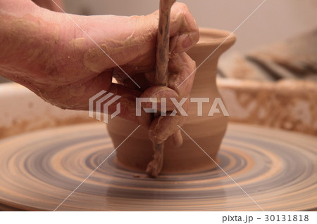 Hands of a potter, creating an earthen jar on 30131818