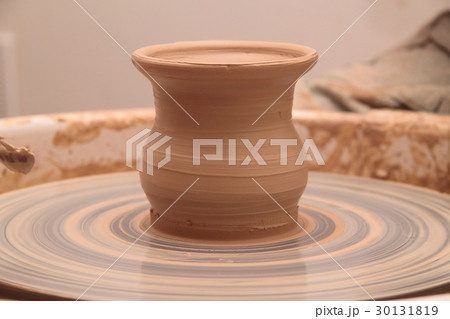 Clay pot on a pottery wheel 30131819