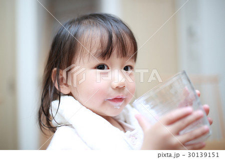 牛乳 子供 ミルク 風呂上がり 幼児 女の子 1才 1歳 飲み物 ドリンク バスタオル パジャマ の写真素材