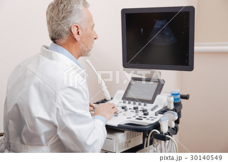 Cheerful aging sonographer using professional Cheerful aging sonographer using professional 30140549