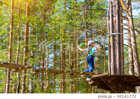 Girl on hinged trail in extreme rope Park Girl on hinged trail in extreme rope Park 30141772