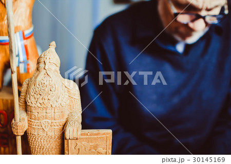 a craftsman carves wood 30145169