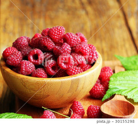 Ripe fresh raspberry in wooden bowl. 30155298