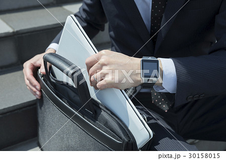 ビジネスバッグからノートパソコンを取り出すビジネスマン 30158015