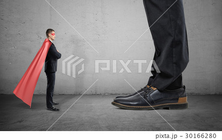 A tiny businessman in a superhero cape stands A tiny businessman in a superhero cape stands 30166280