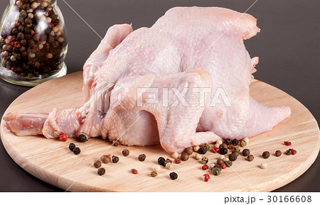 raw chicken carcass with peppercorns on a dark 30166608