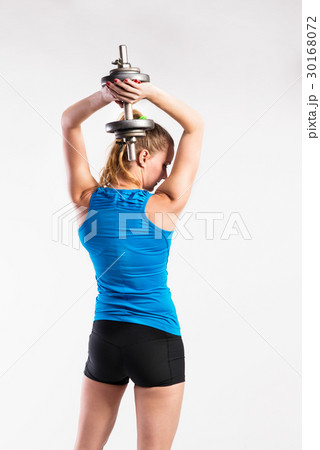 Attractive young fitness woman holding dumbell 30168072