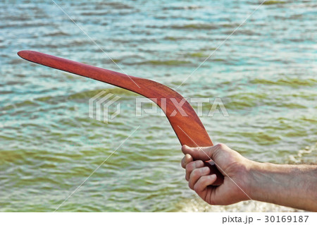 Boomerang in men arm against of the sea. 30169187