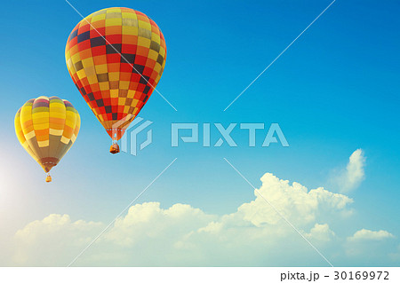 Two colorful hot air balloons up in the blue sky Two colorful hot air balloons up in the blue sky 30169972