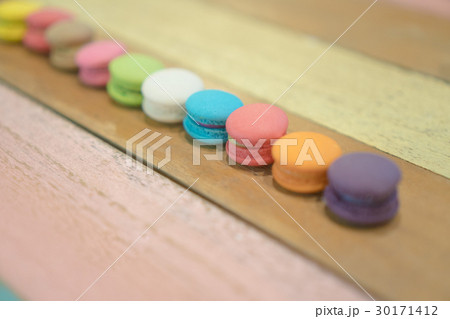 Multicolored macaroons on white wooden background Multicolored macaroons on white wooden background 30171412