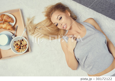 Young beautiful woman having breakfast in bed. Young beautiful woman having breakfast in bed. 30172122