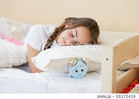 Teenage girl sleeping on alarm clock Teenage girl sleeping on alarm clock 30172416