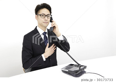 ビジネスフォンで電話対応する男性会社員 ビジネスフォンで電話対応する男性会社員 30173733