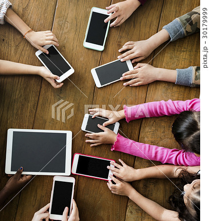 Group of Kids Holding Digital Devices Connect on Wooden Table 30179999