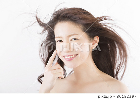 ビューティー 髪の毛 なびく 風 イメージ カメラ目線で笑顔の写真素材