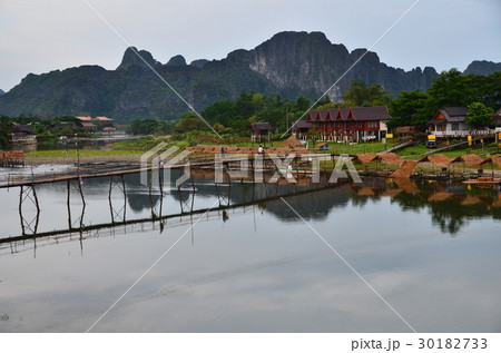 ラオスの景勝地、バンビエン　美しい山とソン川　竹の橋を渡る人々 30182733