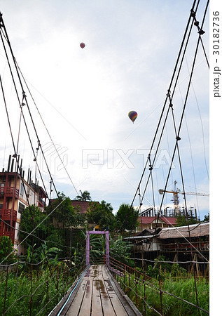 ラオスの景勝地、バンビエン　吊り橋と上空を飛行する熱気球 30182736