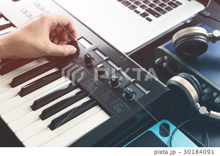 Musician adjusting sound on synthesizer keyboard 30184091