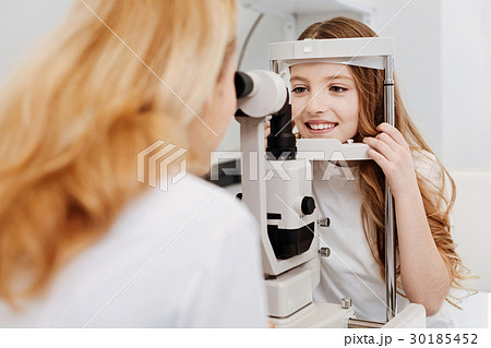 Skillful trained ophthalmologist examining girls Skillful trained ophthalmologist examining girls 30185452