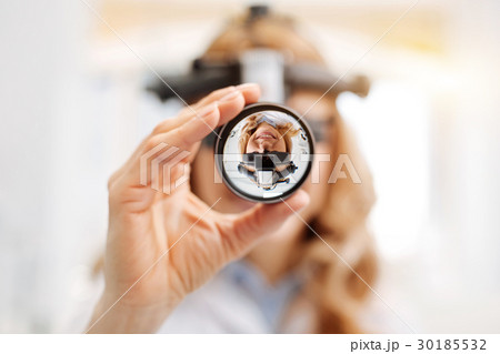 Focused scrupulous ophthalmologist doing a 30185532