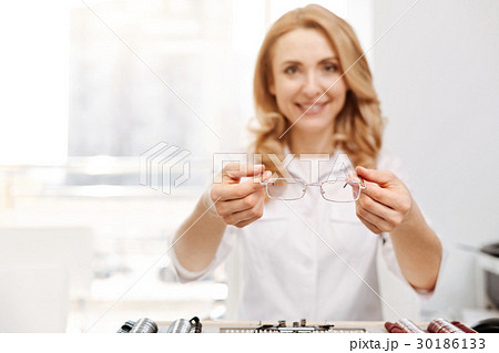 Friendly smiling lady giving out glasses 30186133