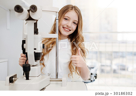 Lively adorable child testing her eyesight Lively adorable child testing her eyesight 30186302