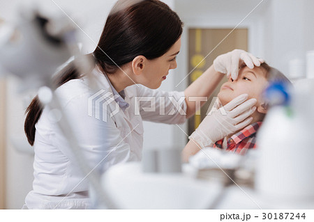 Serious otolaryngologist examining nose problems Serious otolaryngologist examining nose problems 30187244