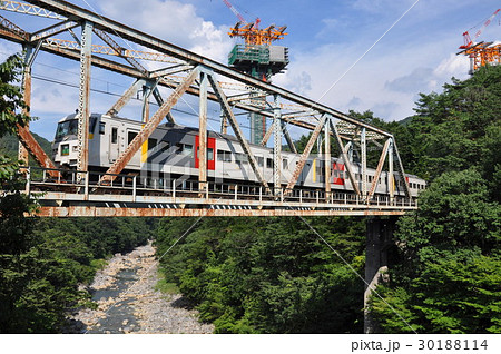 巨大高架橋脚の下の鉄橋を渡るカラフルな電車 30188114