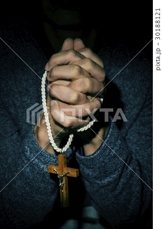 young man with a crucifix in his hands young man with a crucifix in his hands 30188121
