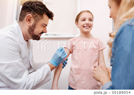 Delighted male doctor doing an injection 30189054