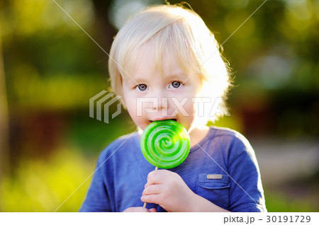 Cute toddler boy with big green lollipop Cute toddler boy with big green lollipop 30191729