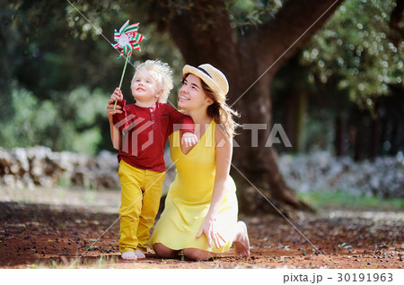 Female farmer and her little helper working in olive grove in Italy Female farmer and her little helper working in olive grove in Italy 30191963