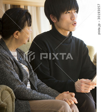 祖母と写真を見る孫 30193057