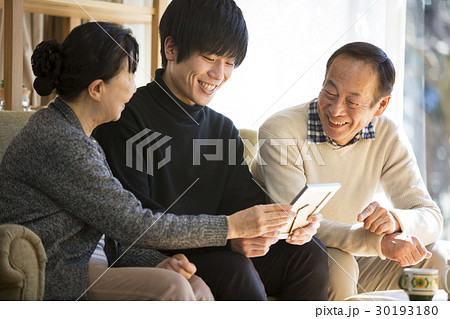 祖父母と写真を見る孫 30193180