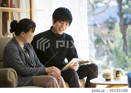 祖母と写真を見る孫 30193196